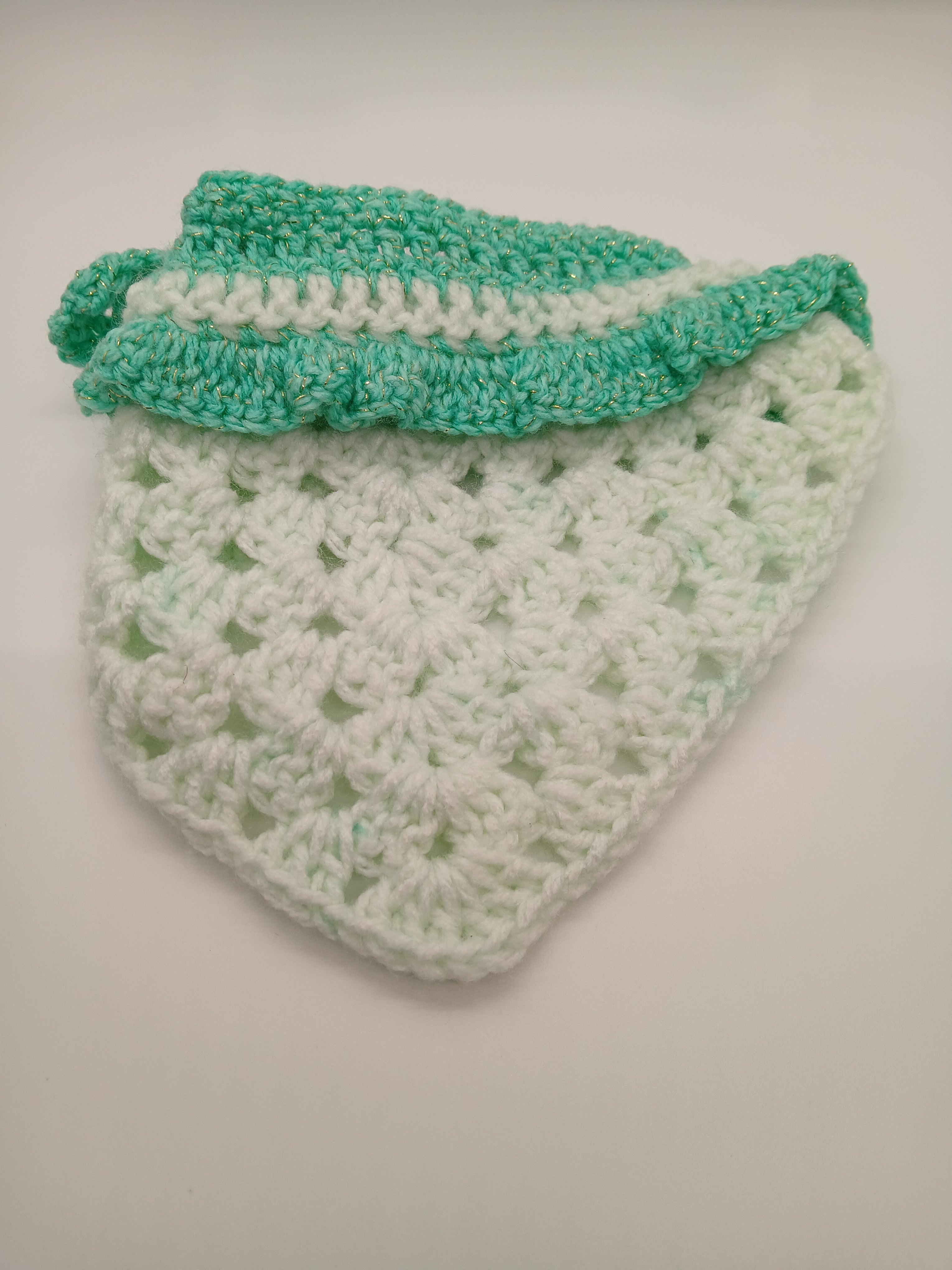 Front view of Oma Regina's newest crochet dog bandana in green hues. Adjustable, handmade in the USA, light mint green and glitter green acrylic yarn. 