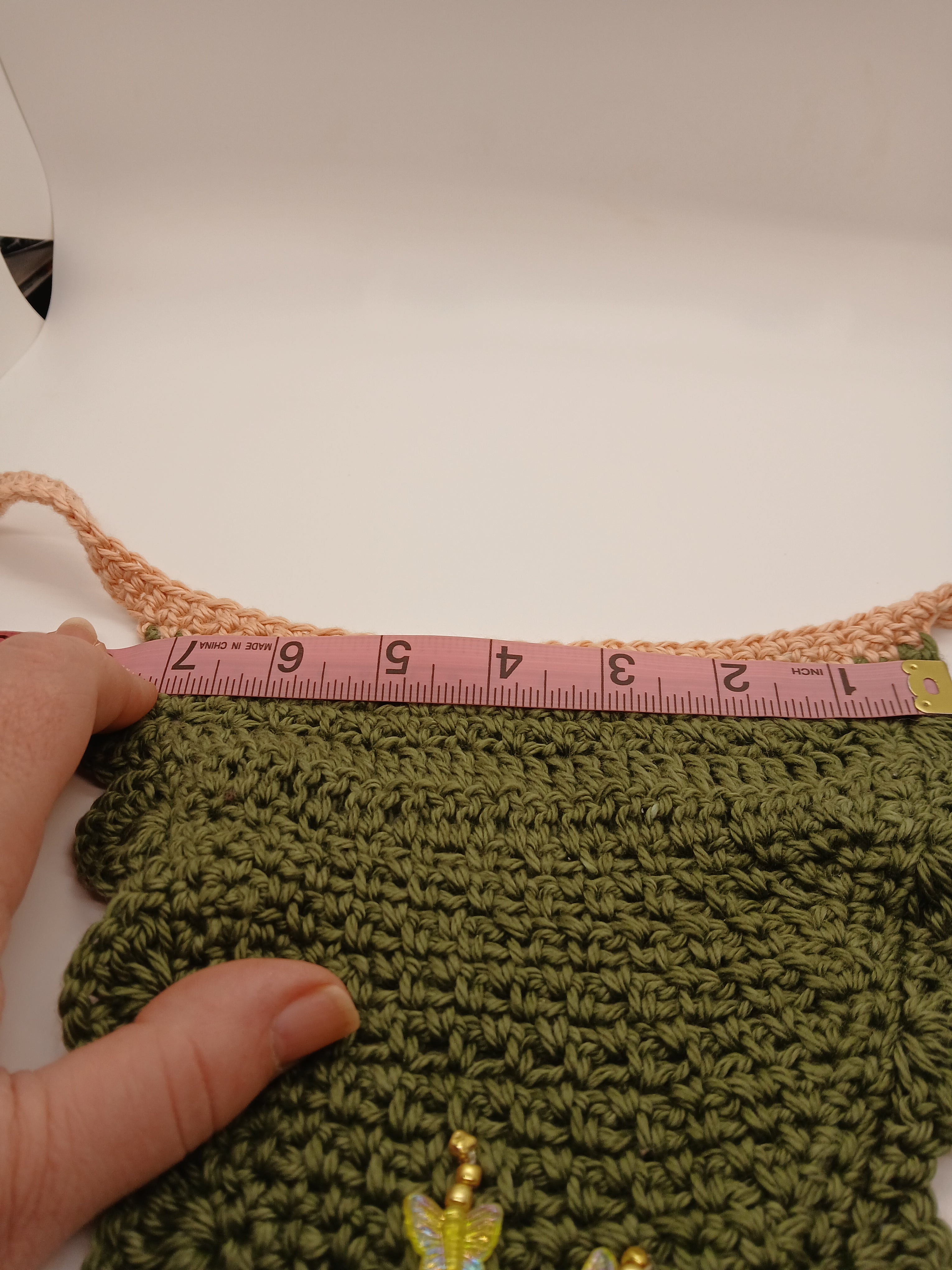 7.5 inches along the "bib" of crochet dog bandana for mid-sized pups. Picture shows measuring tape along the top for better size context. 